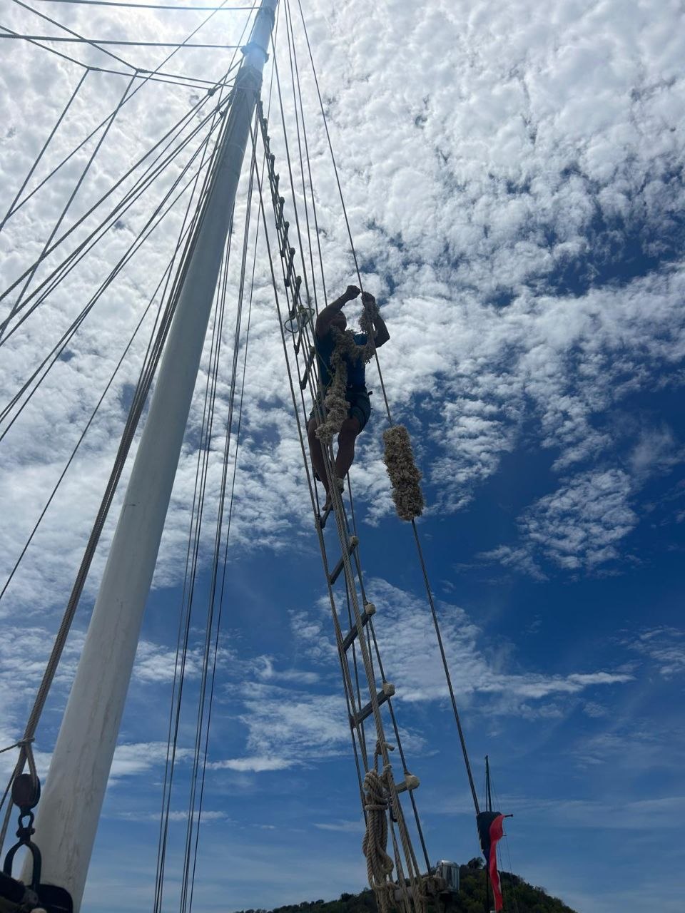 Working high in Cherub's rigging under a cloudy sky