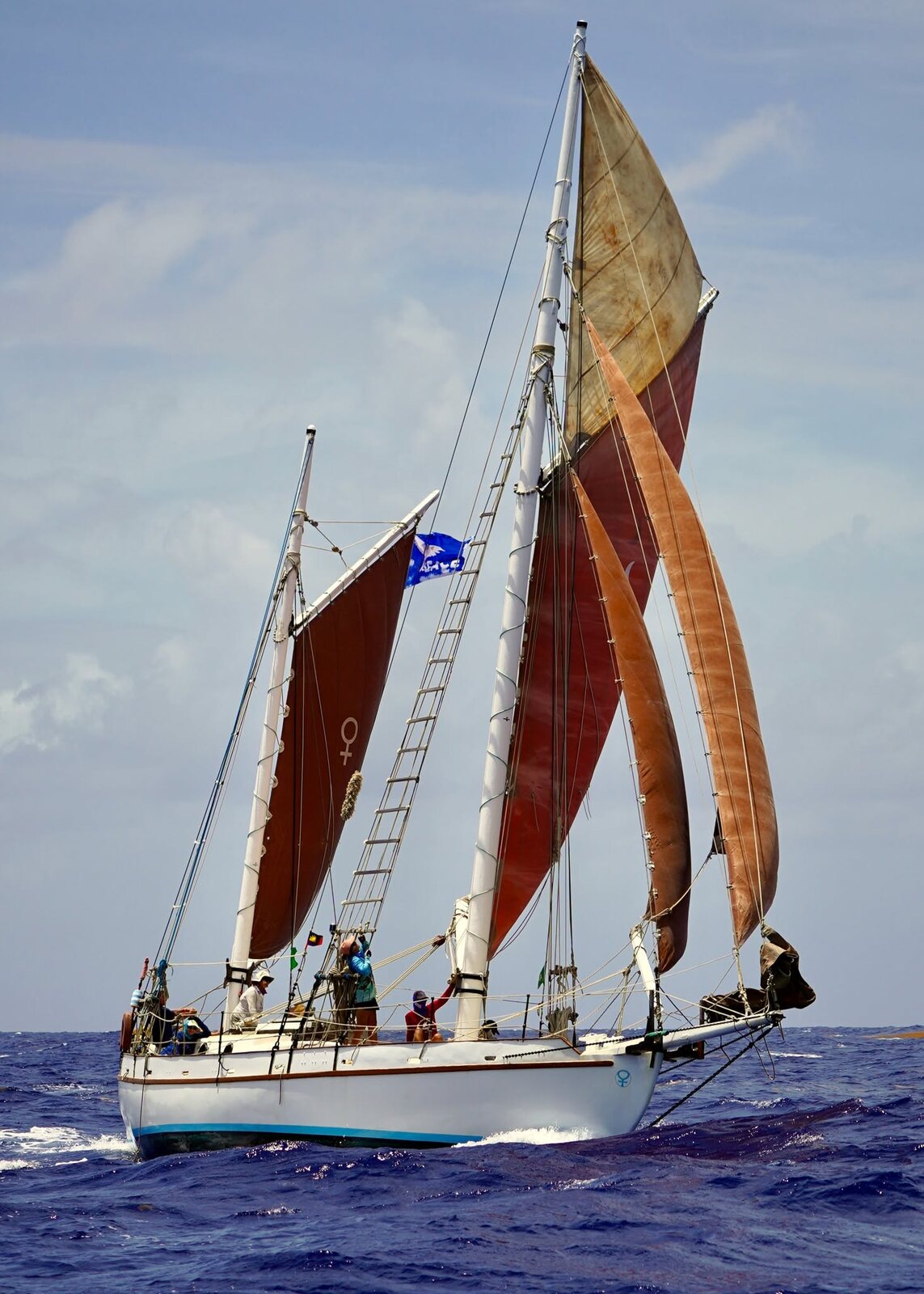 Cherub sailing offshore under tan canvas in open water